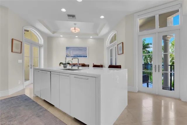 a kitchen with kitchen island granite countertop a refrigerator and a sink