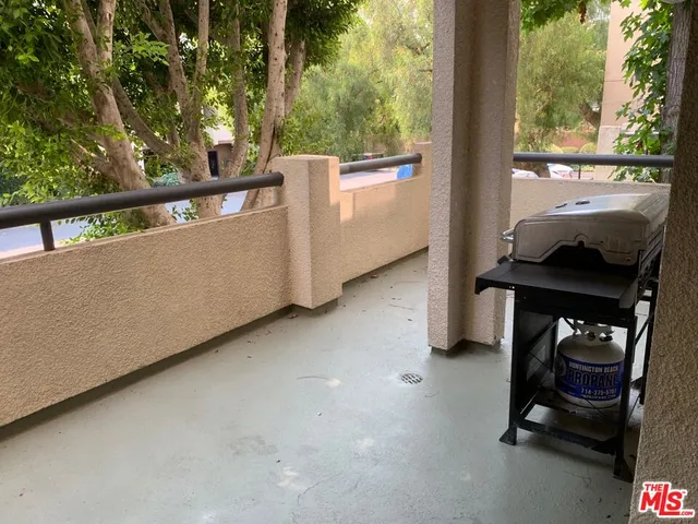 an empty room with wooden floor fireplace and windows