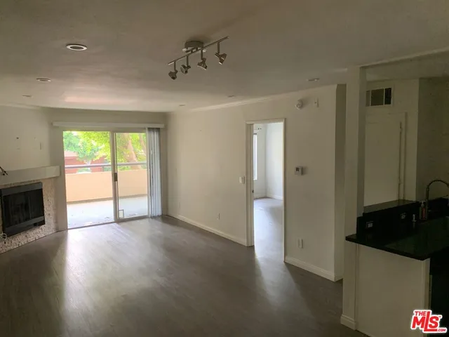 a view of an empty room with a fireplace and a window