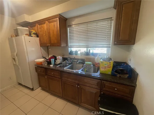 a kitchen with granite countertop cabinets and refrigerator