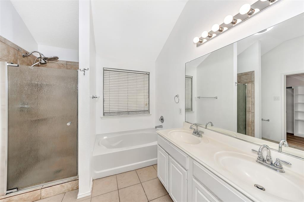 1006 Buckingham Drive Forney, TX 75126 - Photo 13 of 31 a bathroom with a granite countertop sink a mirror and a bathtub