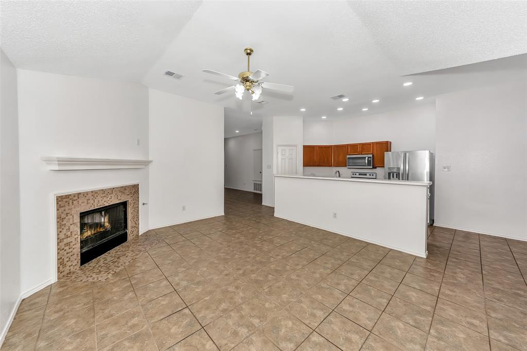 1006 Buckingham Drive Forney, TX 75126 - Photo 6 of 31 a view of a kitchen with a sink a fireplace a kitchen island and chandelier