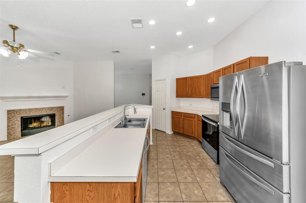 1006 Buckingham Drive Forney, TX 75126 - Photo 7 of 31 a kitchen with a refrigerator and a stove top oven
