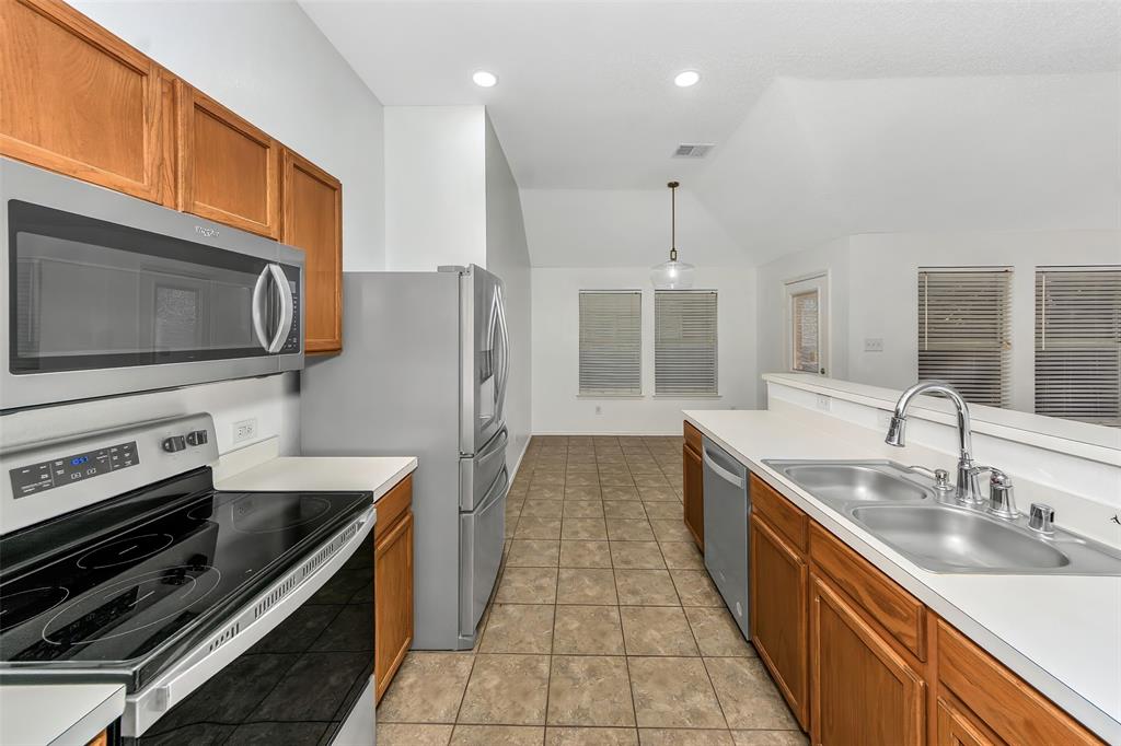 1006 Buckingham Drive Forney, TX 75126 - Photo 8 of 31 a kitchen with stainless steel appliances granite countertop a sink stove and refrigerator