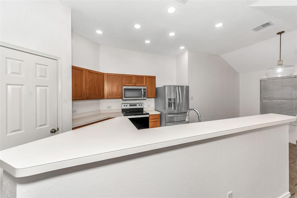 1006 Buckingham Drive Forney, TX 75126 - Photo 10 of 31 a kitchen with stainless steel appliances a refrigerator and a stove