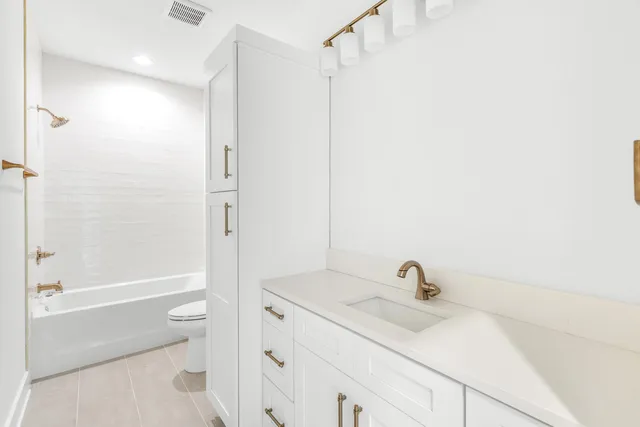 a bathroom with a sink toilet vanity and shower