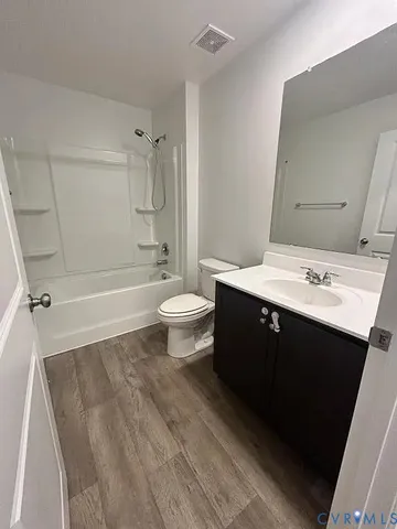 a bathroom with a double vanity sink toilet mirror and bathtub