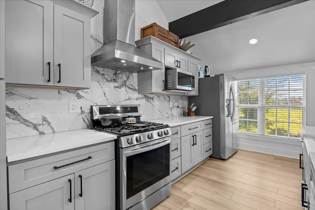 a kitchen with stainless steel appliances a stove a sink and a refrigerator