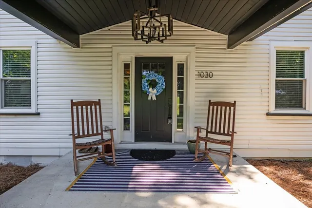 a view of a door of the house with wooden floor and fence