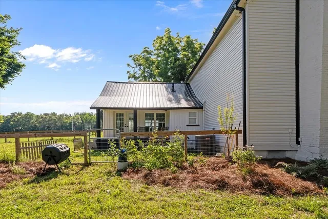 a backyard of a house with yard table and chairs