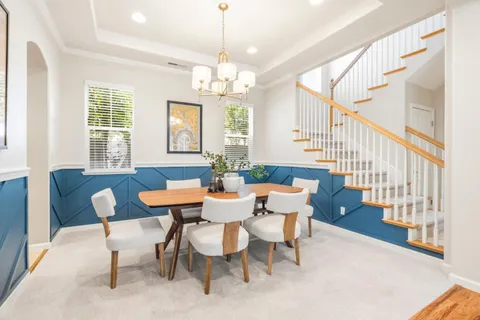 a view of a dining room with furniture a chandelier and wooden floor