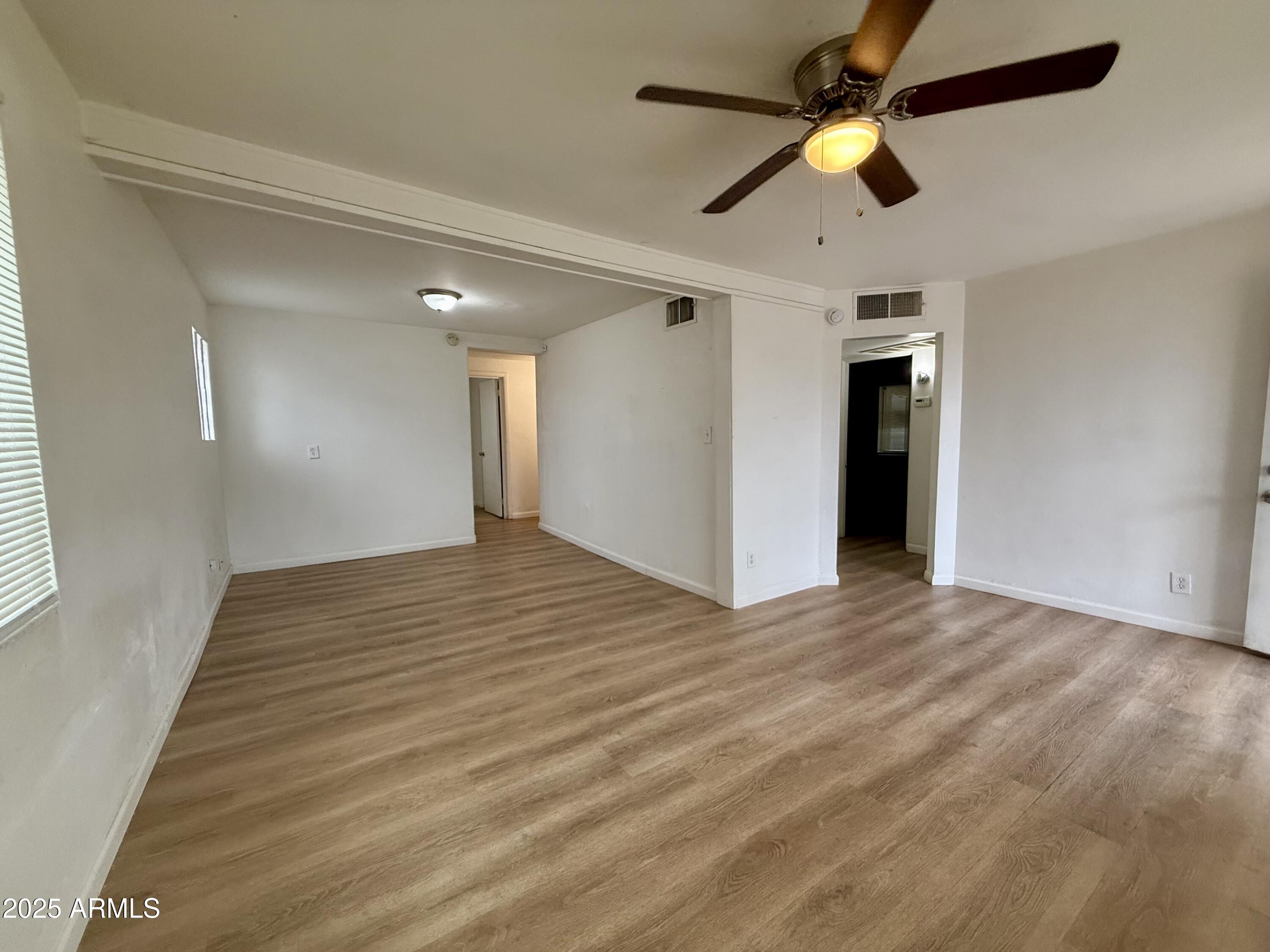 1218 West Cinnabar Avenue Phoenix, AZ 85021 - Photo 6 of 31 a view of empty room with wooden floor and fan