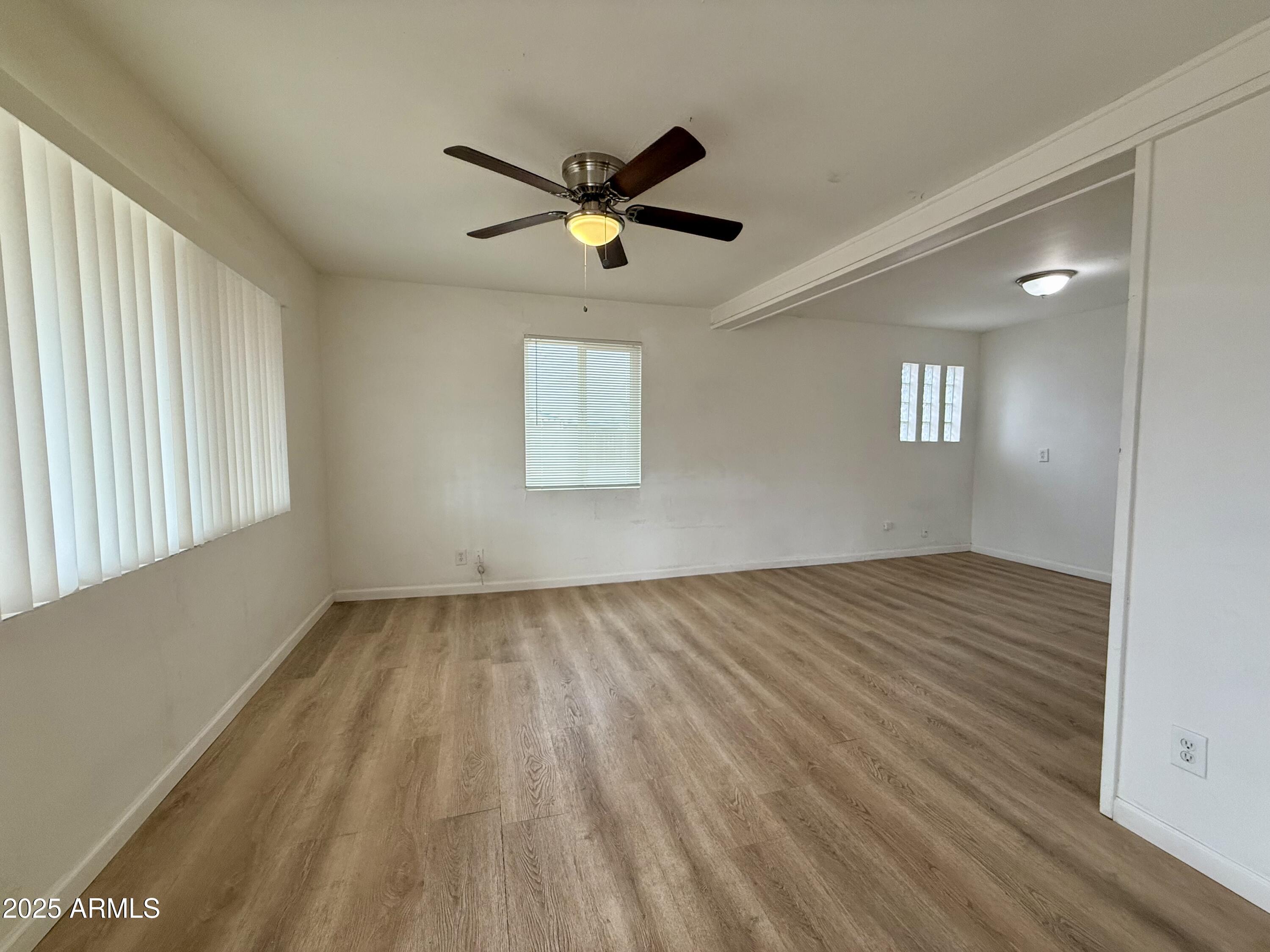 1218 West Cinnabar Avenue Phoenix, AZ 85021 - Photo 9 of 31 a view of empty room with wooden floor and fan