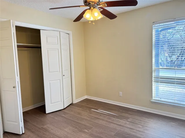 a view of an empty room with chandelier fan and fire place