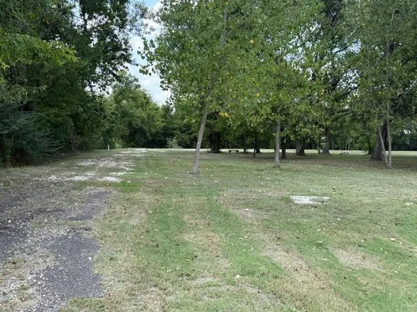 a view of a green field with trees in the background