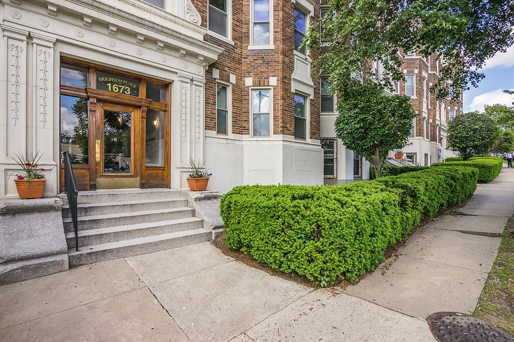 a front view of a multi story building with a yard