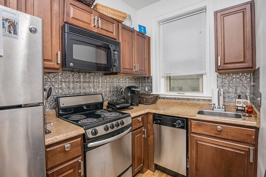 1673 Commonwealth Avenue, Unit 3 Boston, MA 02135 - Photo 7 of 10 a kitchen with cabinets stainless steel appliances and a sink