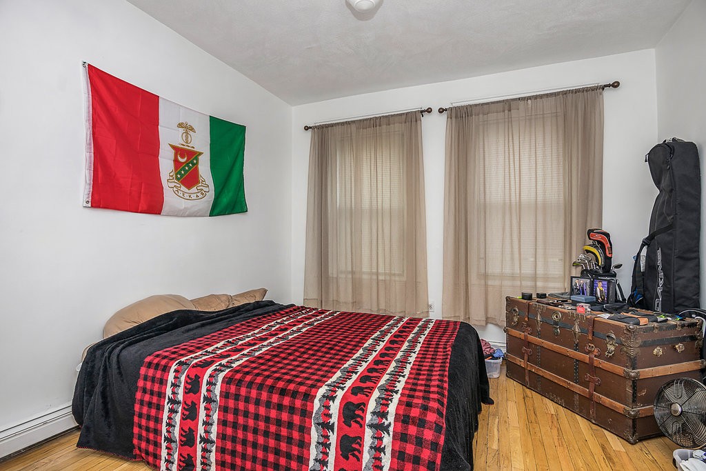 1673 Commonwealth Avenue, Unit 3 Boston, MA 02135 - Photo 9 of 10 a bedroom with a bed and a dresser with bookshelf