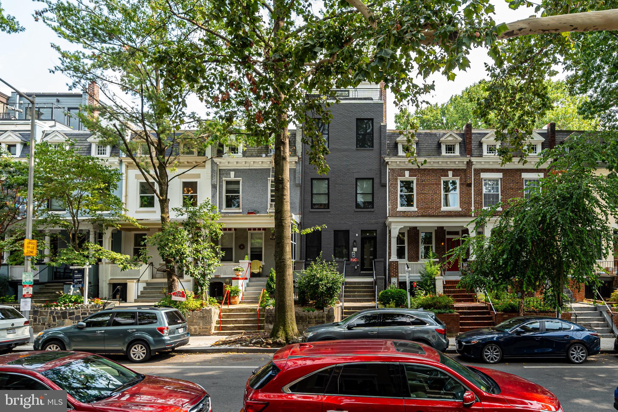 a front view of a building with car parked