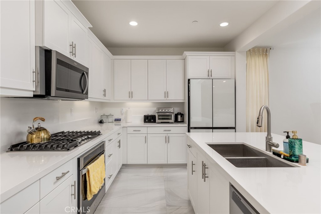 31124 Hanover Lane Menifee, CA 92584 - Photo 9 of 39 a kitchen with granite countertop a sink a stove and cabinets