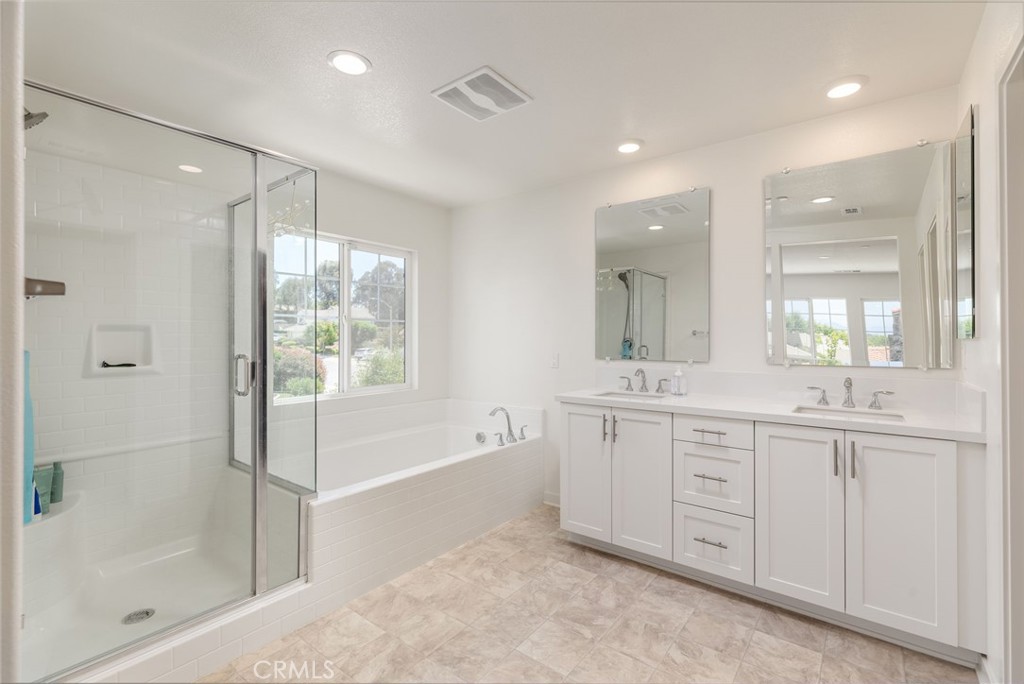 31124 Hanover Lane Menifee, CA 92584 - Photo 16 of 39 a spacious bathroom with a mirror a shower and vanity