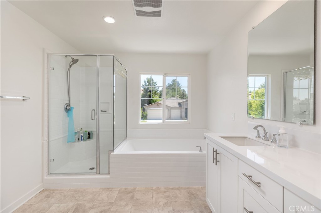 31124 Hanover Lane Menifee, CA 92584 - Photo 17 of 39 a bathroom with a granite countertop tub sink and mirror