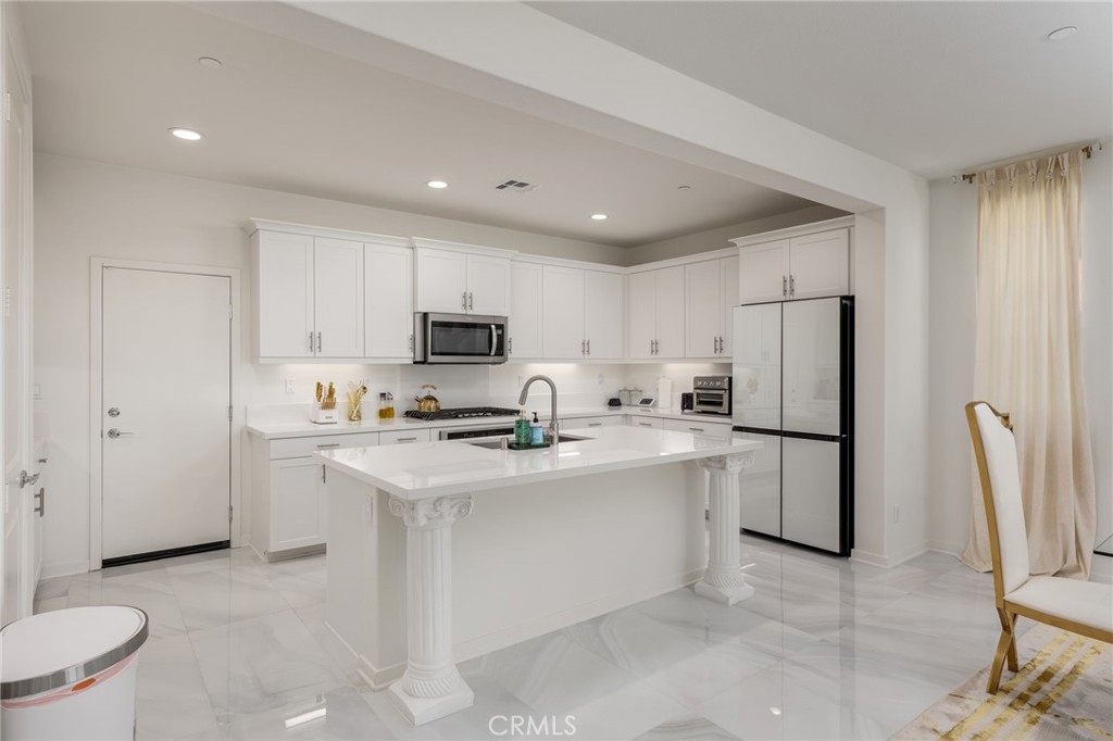 31124 Hanover Lane Menifee, CA 92584 - Photo 8 of 39 a kitchen with stainless steel appliances a refrigerator sink and cabinets