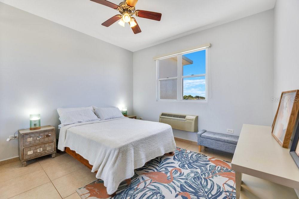 413 Camino Carretas, Unit A7 Rincon, Rincón 00677 - Photo 10 of 23 a bedroom with a bed and a chandelier