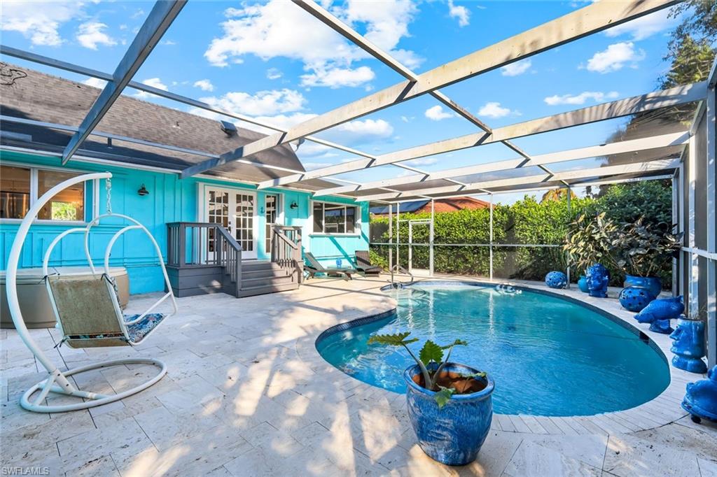 4352 Parrot Avenue Naples, FL 34104 - Photo 20 of 27 a view of a swimming pool with a dining table and chairs