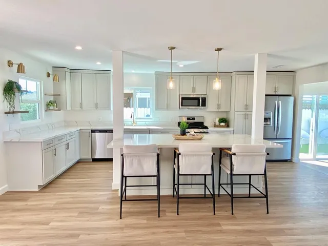 a kitchen with a table chairs refrigerator and cabinets