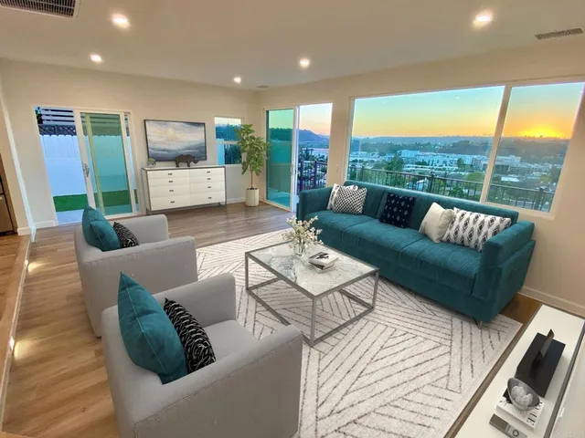 a living room with furniture flat screen tv and a large window