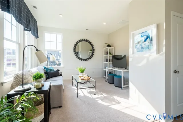 a living room with furniture a rug and white walls