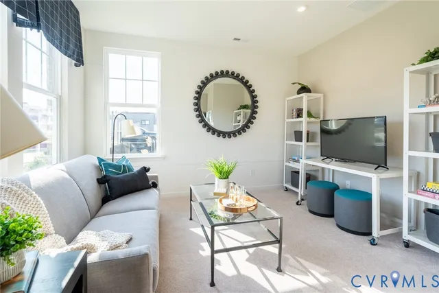 a living room with furniture a flat screen tv and a window