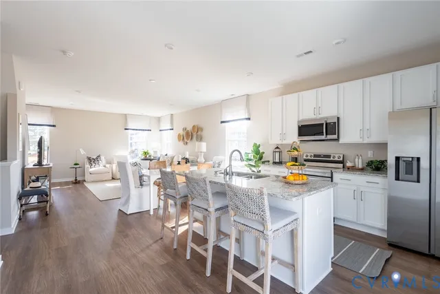 a view of a kitchen with dining table chairs and wooden floor