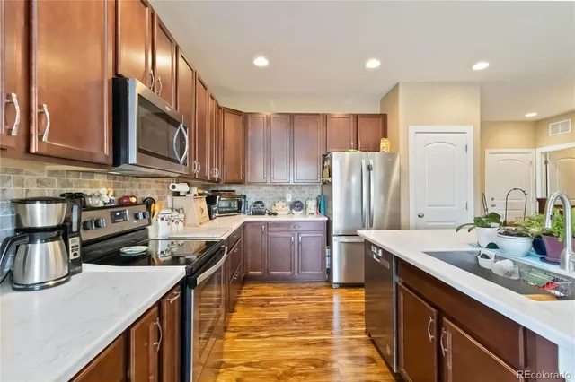 a kitchen with kitchen island granite countertop a sink stove and refrigerator