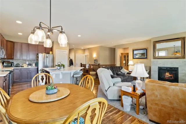 a living room with fireplace a dining table and chairs