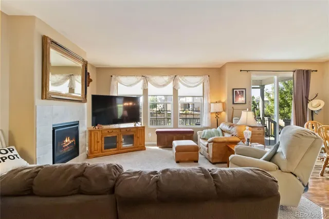 a living room with furniture a flat screen tv and a fireplace