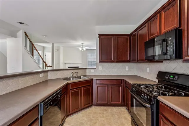 a kitchen with stainless steel appliances a sink dishwasher stove and oven