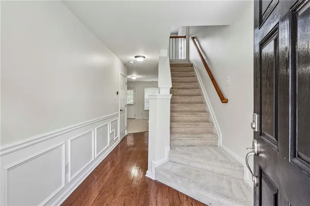 a view of staircase with lots of frames on wall and wooden floor