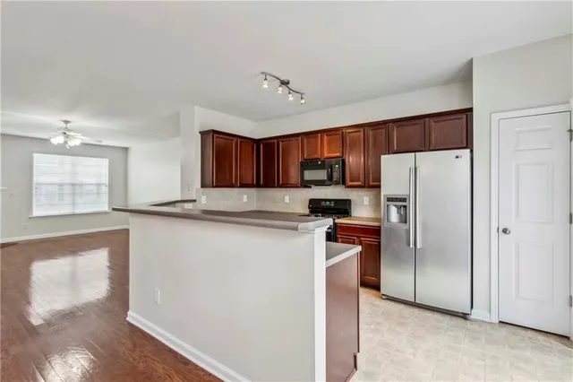 a kitchen with stainless steel appliances a refrigerator sink and microwave