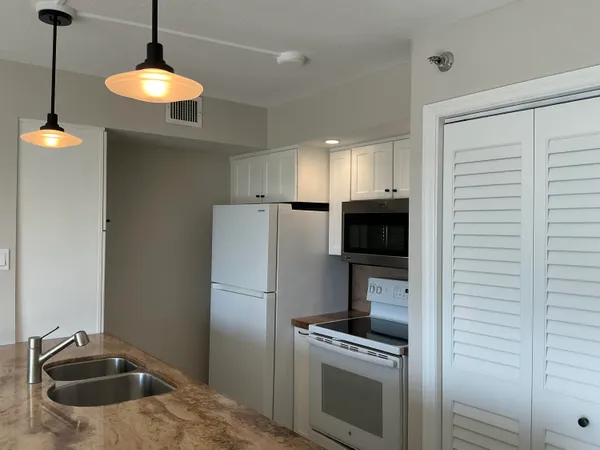 a kitchen with a refrigerator and a stove top oven