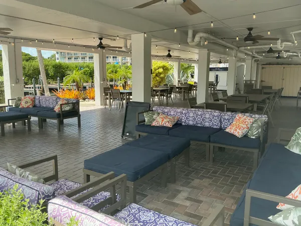 a living room filled with lots of furniture hardwood floor and a floor to ceiling window