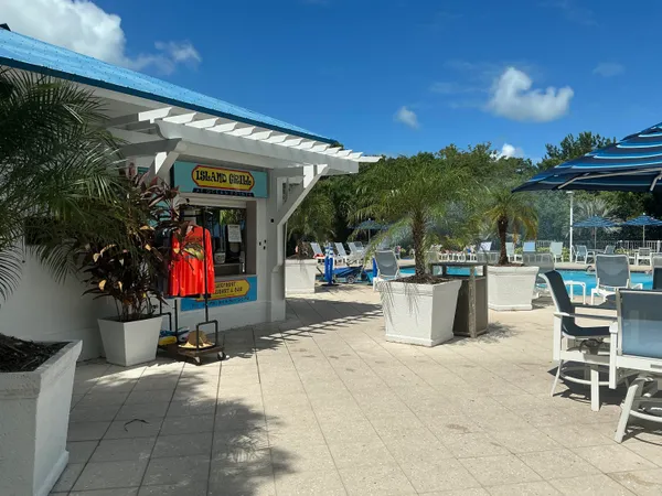 a view of a patio with dining table and chairs under an umbrella with a patio