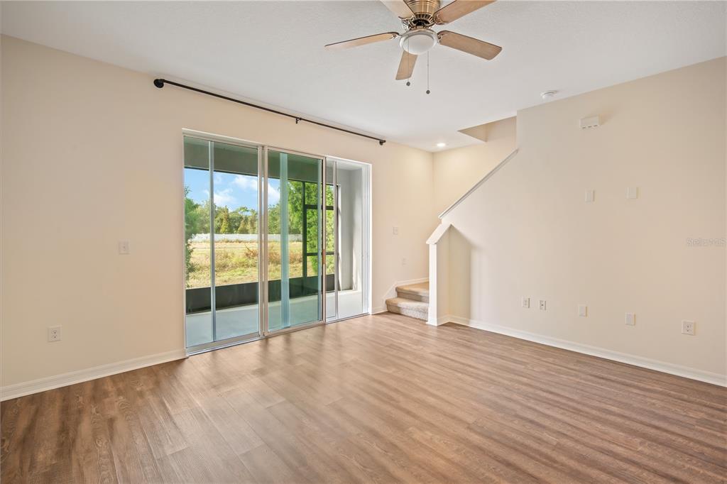 8619 Falling Blue Place Riverview, FL 33578 - Photo 11 of 27 an empty room with wooden floor and fan