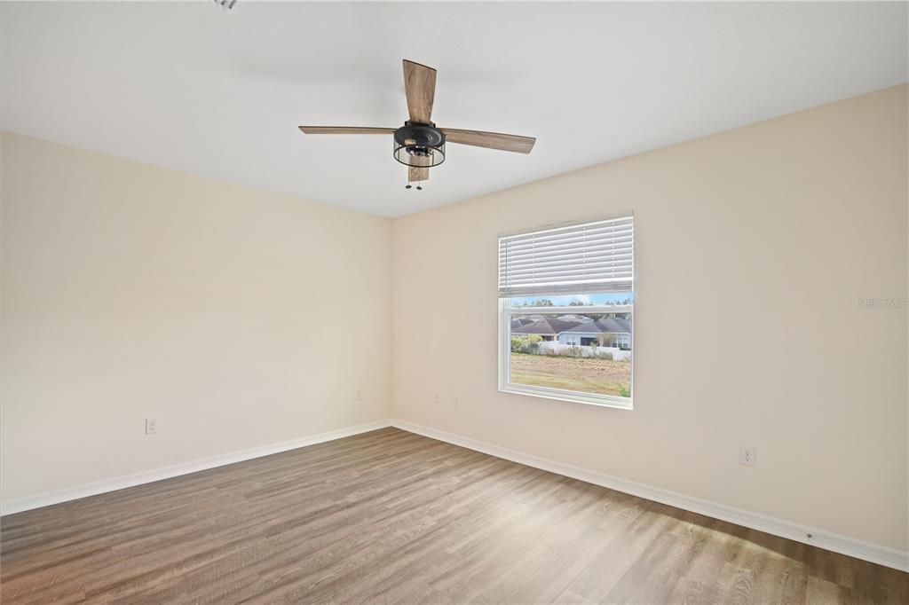8619 Falling Blue Place Riverview, FL 33578 - Photo 14 of 27 an empty room with wooden floor ceiling fan and windows
