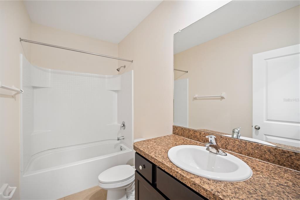 8619 Falling Blue Place Riverview, FL 33578 - Photo 17 of 27 a bathroom with a granite countertop sink a toilet and shower