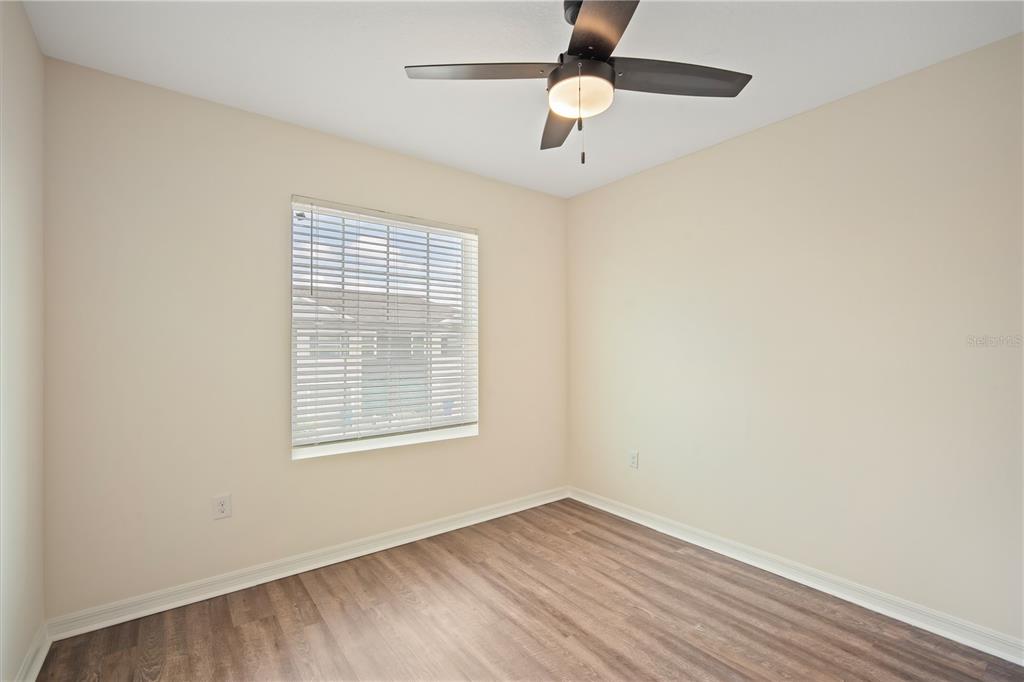 8619 Falling Blue Place Riverview, FL 33578 - Photo 21 of 27 an empty room with wooden floor fan and windows