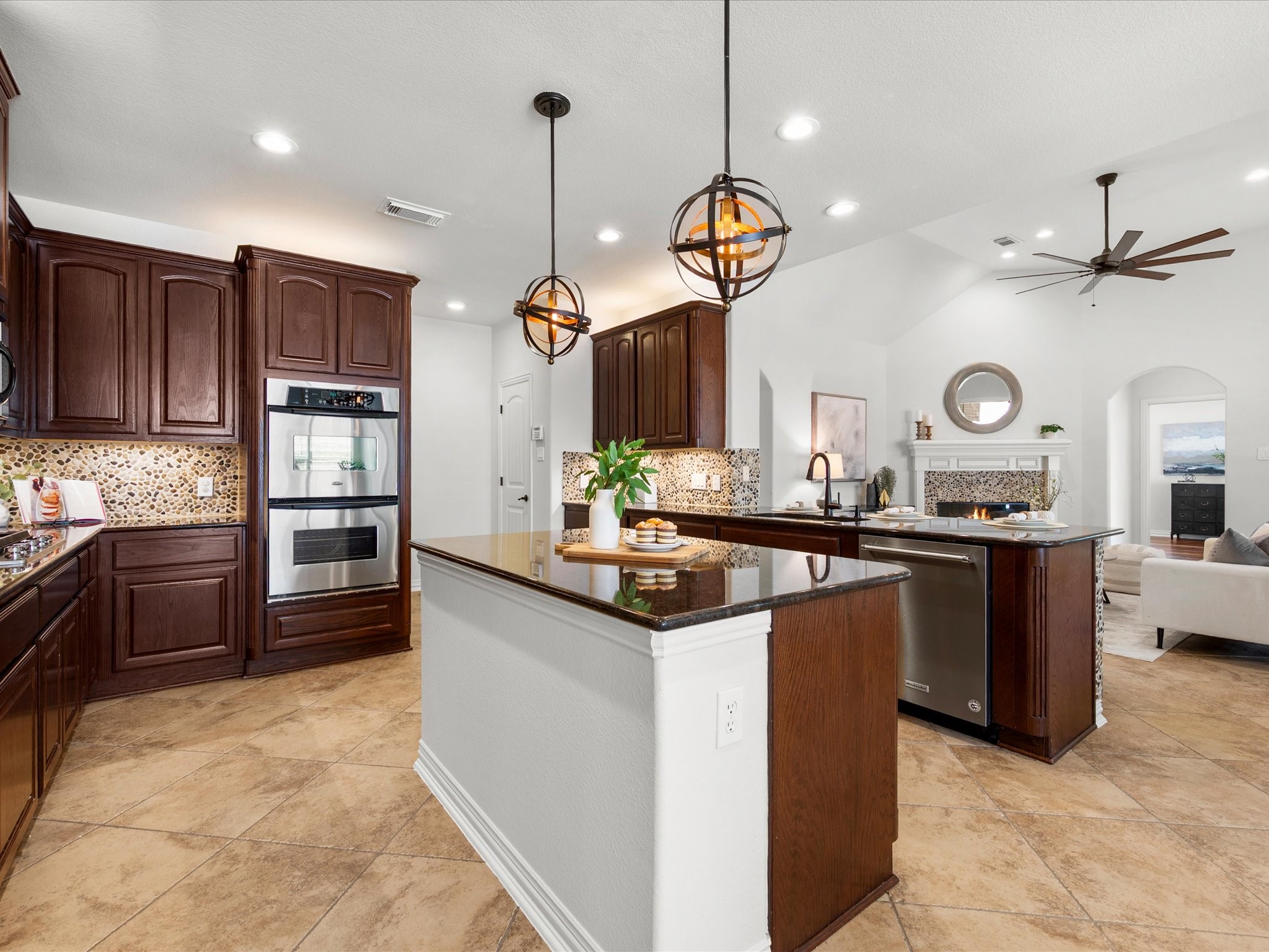 323 Arbor Ridge Lane Conroe, TX 77384 - Photo 8 of 40 Now we're talking. Double ovens, gas cooktop, granite island, and those statement pendants tying it all together. The cook in the family is going to lose their mind in here.