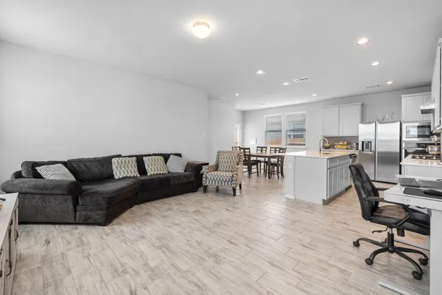 a living room with furniture and a wooden floor