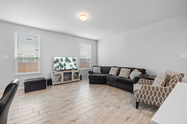 a living room with furniture flat screen tv and hard wood floor